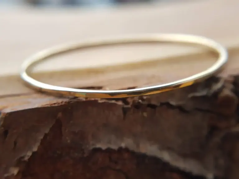 Close-up of a Silver ring on rough wooden surface.