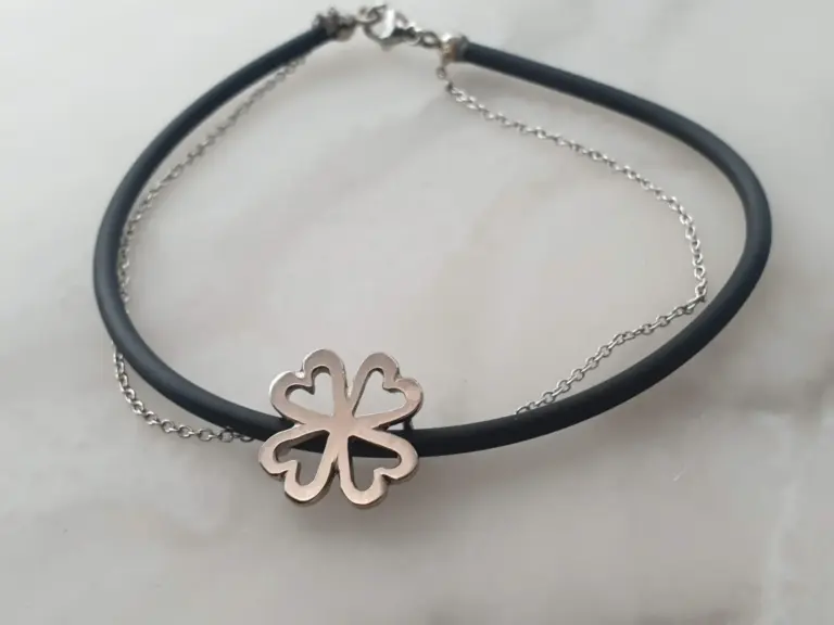Silver four-leaf clover pendant necklace on black and silver chains.