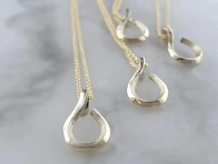 Silver bracelet and earrings with abstract open circle design on a light gray surface.
