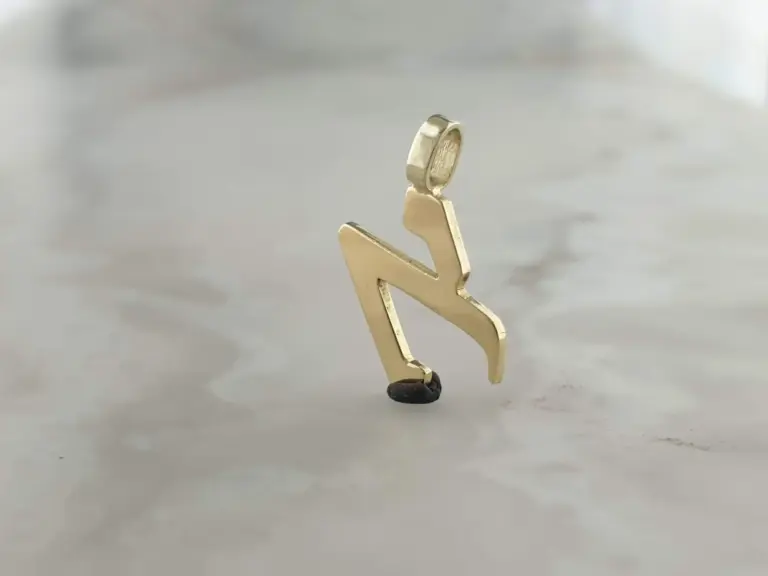 A small gold-colored humanoid figurine holding a tiny open jewelry box with a ring inside, standing on a plain surface.