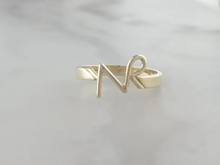 Gold ring with a letter 'N' and a letter 'R' wirewrapped onto the band.