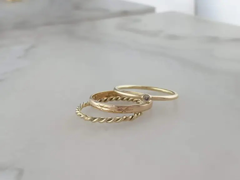 Gold rings with intricate designs on a white surface